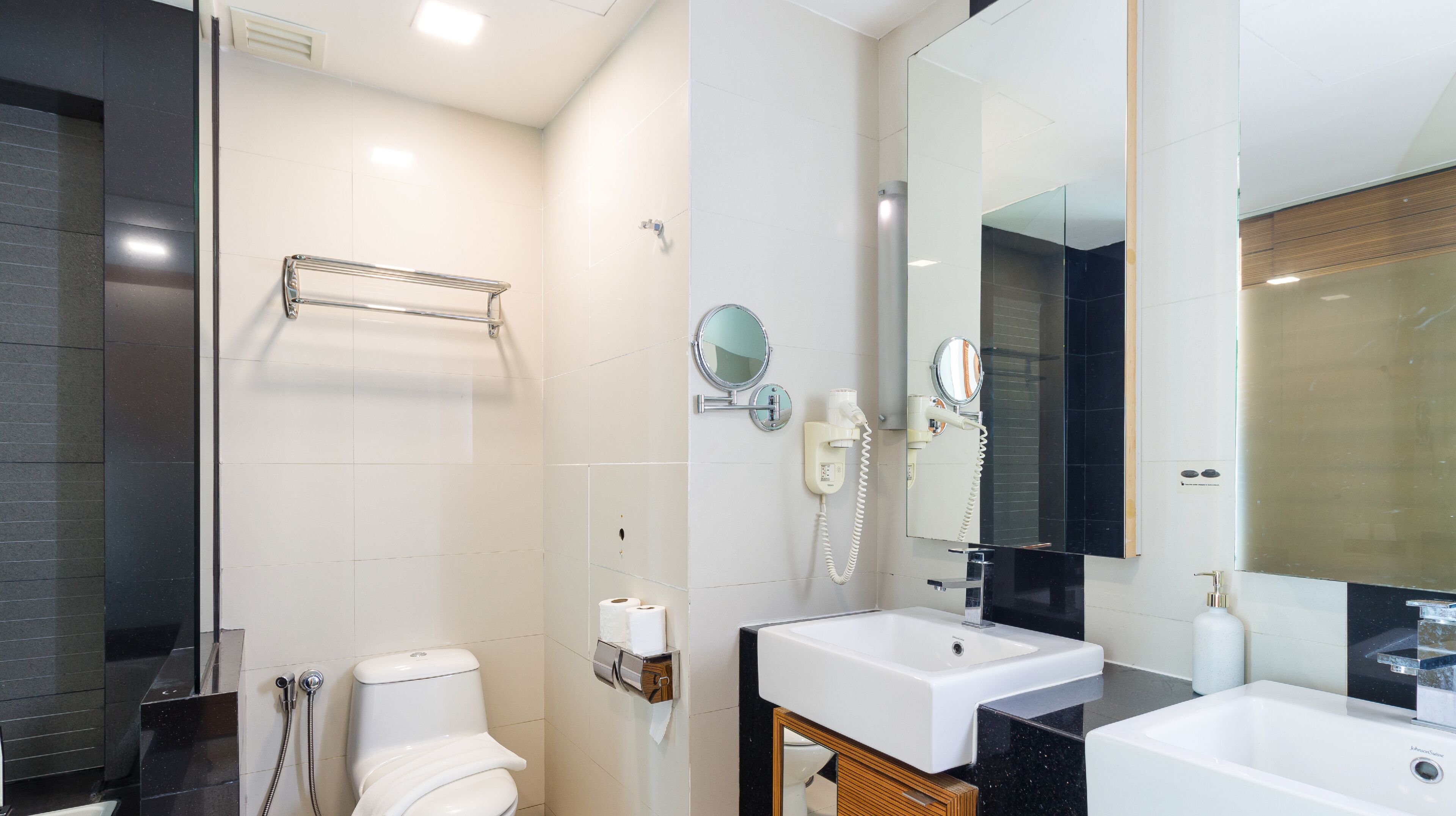 A modern bathroom with a toilet, bidet, and two sinks.