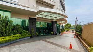 A modern building with a curved entrance, glass doors, and a landscaped area with plants. - Dua Sentral KL Sentral (Kuala Lumpur)