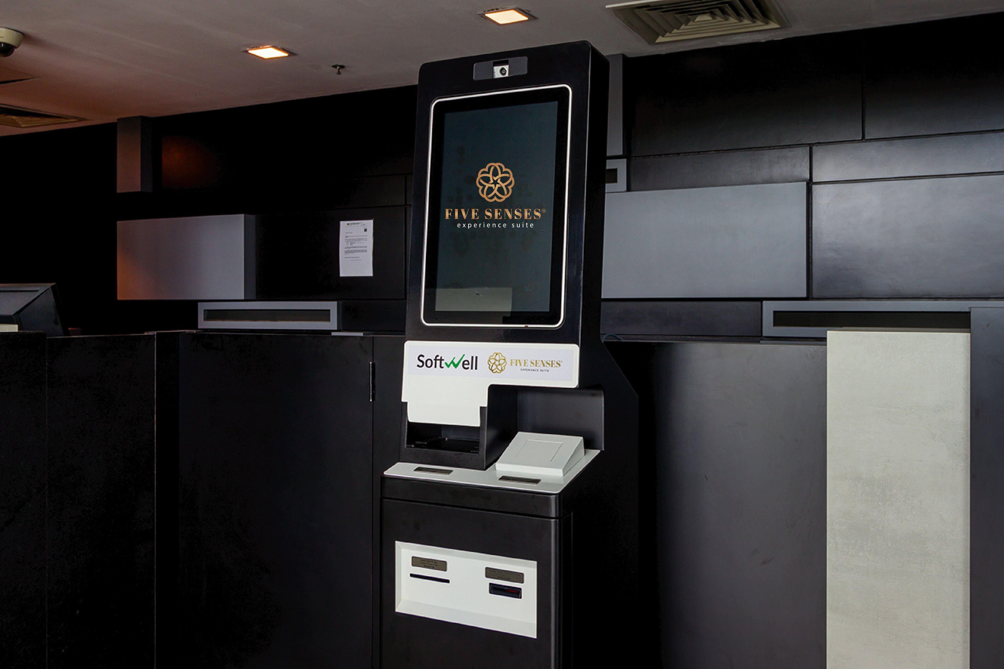 A self-service kiosk with a logo and the text "Five Senses experience suite" and "Softwell" on it.