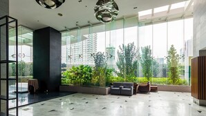 A spacious lobby with a modern design, featuring a large glass wall, a seating area with sofas, and a view of the cityscape. - Dua Sentral KL Sentral (Kuala Lumpur)