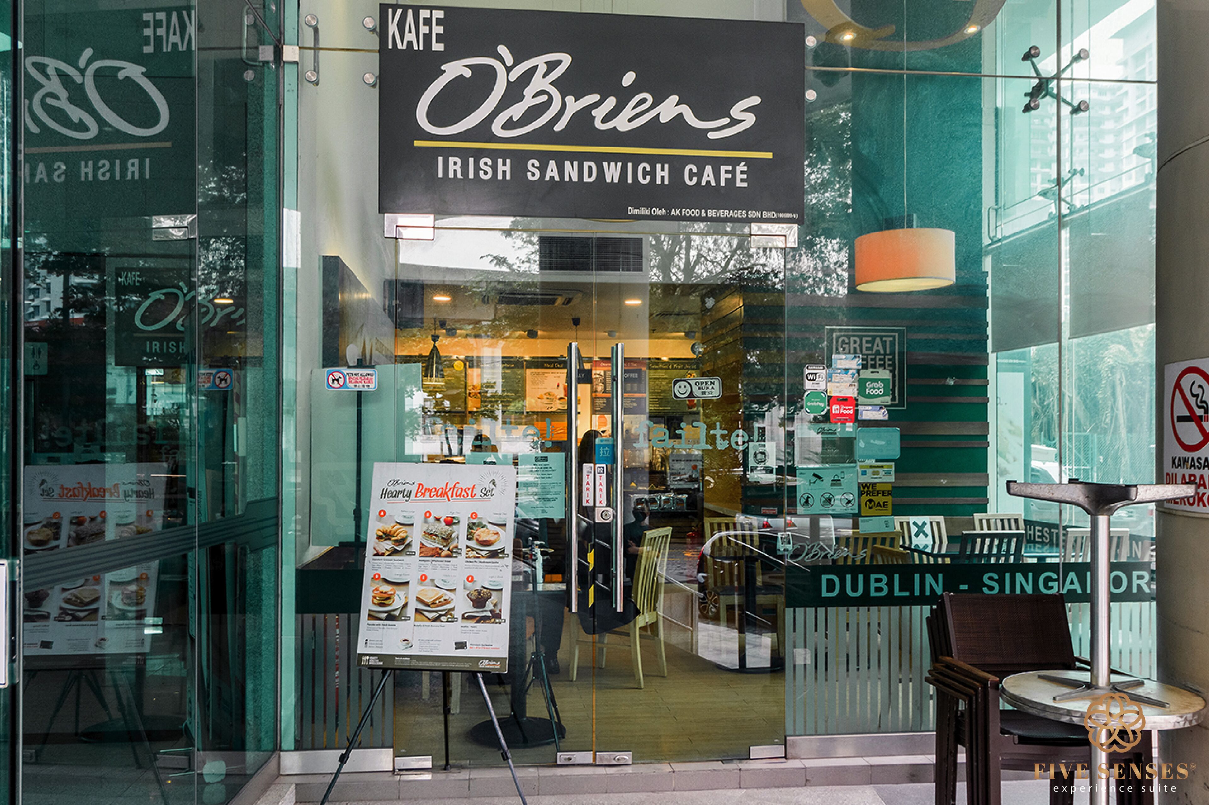 The exterior of O'Brien's Irish Sandwich Café with a clear view of the entrance, menu boards, and seating area visible through the glass doors.