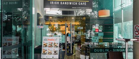 The exterior of O'Brien's Irish Sandwich Café with a clear view of the entrance, menu boards, and seating area visible through the glass doors.