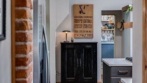 Een moderne keuken met een houten vloer, een zwart kastje en een bord aan de muur.