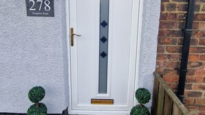 A white door with a number plate reading "278" and a hanging basket with flowers. - 2-Bed Home - Sleeps 4, Parking & Garden (Darlington)