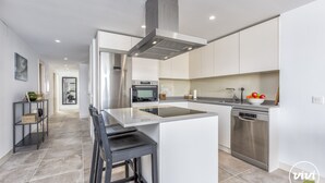 A modern kitchen with a central island, stainless steel appliances, and a minimalist design. - Sara | Sea view - pool - terrace (La Cala de Mijas)