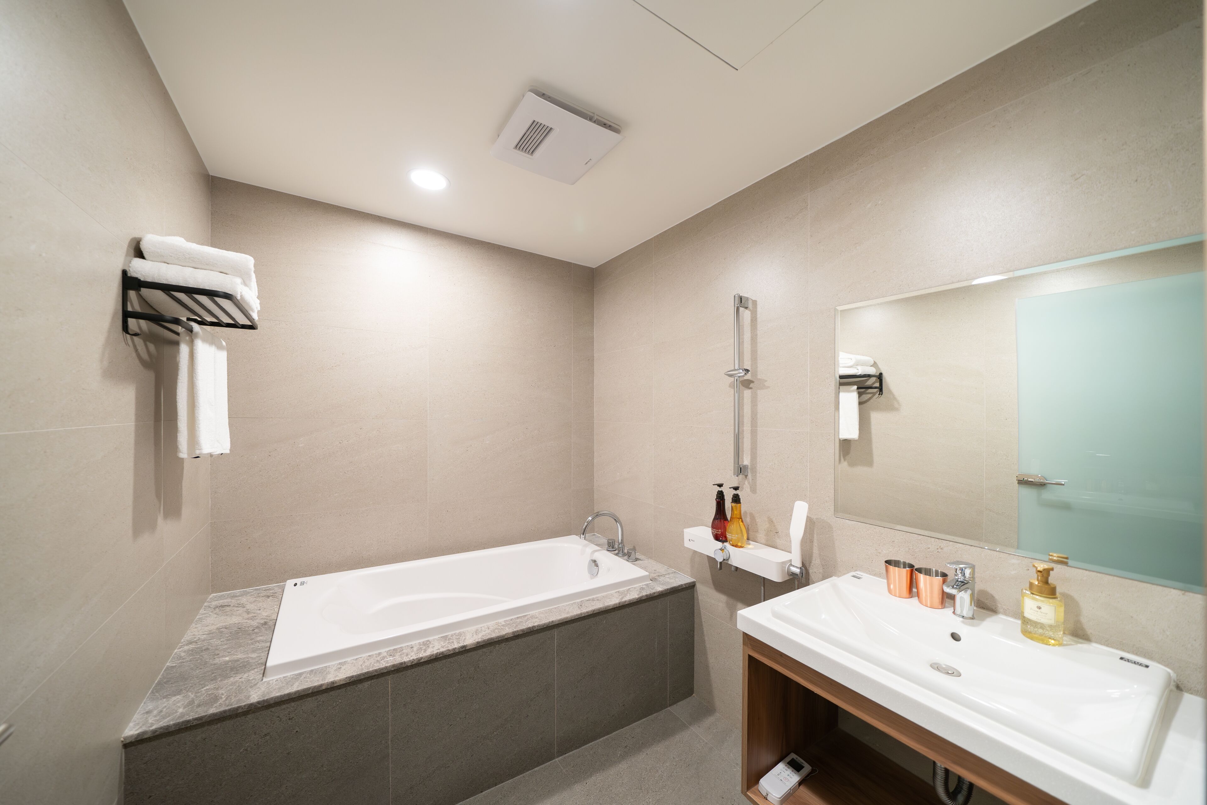 Un baño moderno con bañera, lavabo y espejo.