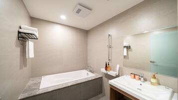 Un baño moderno con bañera, lavabo y espejo.