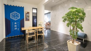 A modern hotel lobby with a reception desk, seating area, and a potted plant. - Kashotsu Bettei (Taichung)