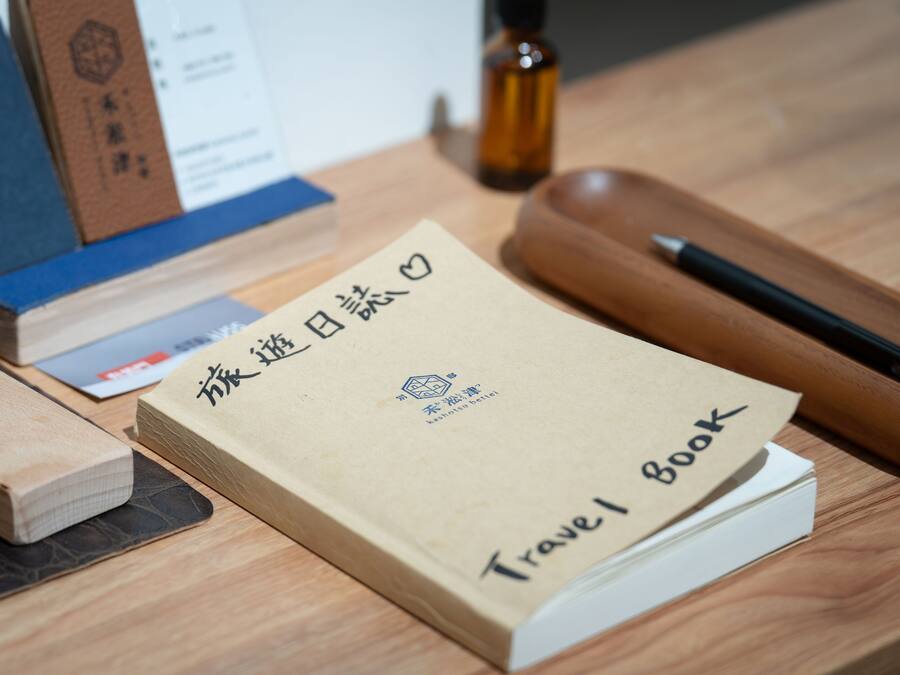 A travel book with foreign text on a wooden table.