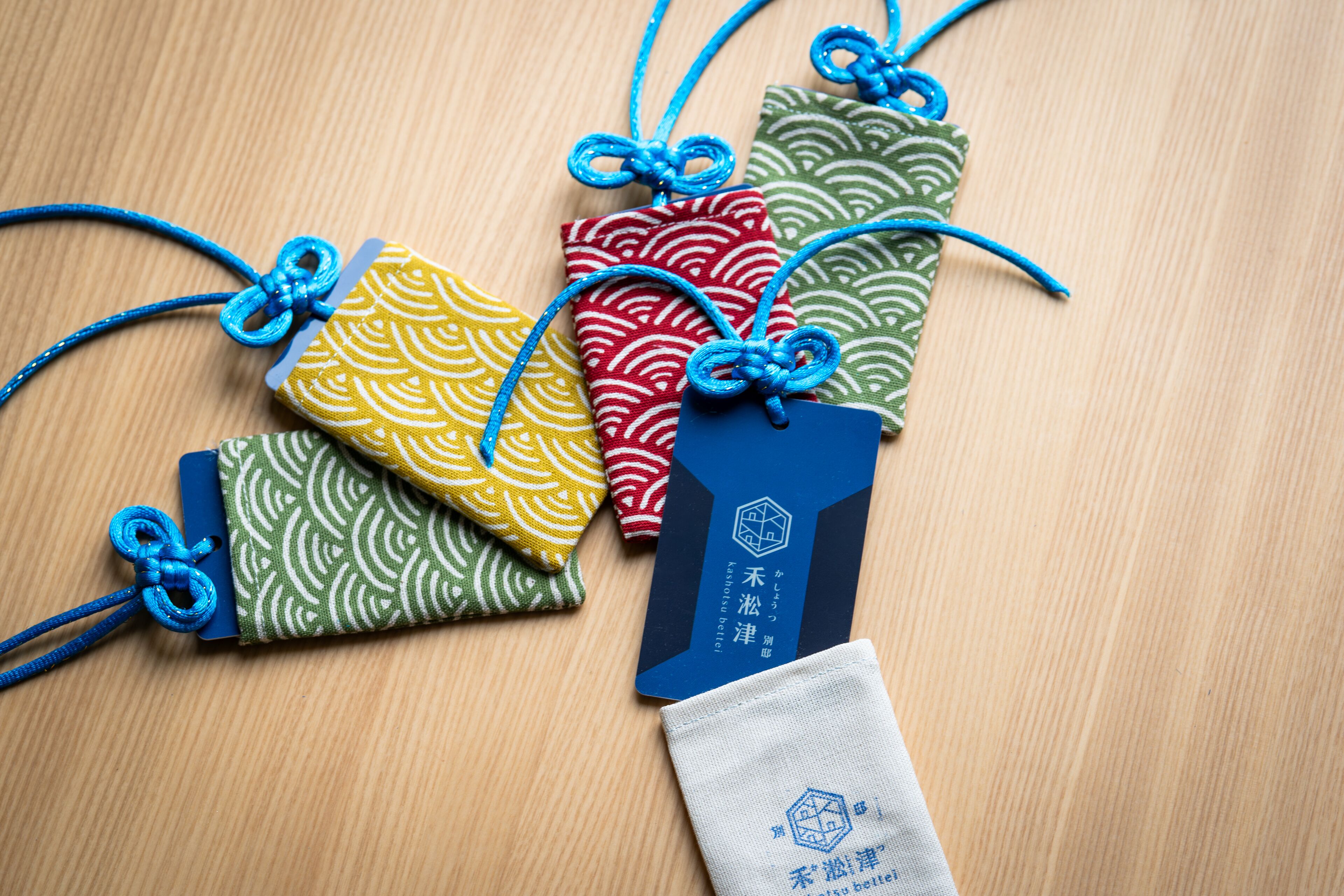 A set of colorful fabric tags with blue strings, each tied with a knot.