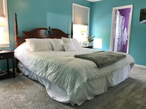 A bedroom with a large bed, a nightstand, a lamp, and a window with blinds. - Spacious 3 Bedroom in Downtown Danville: Welcome to 4th Street Retreat (Danville)