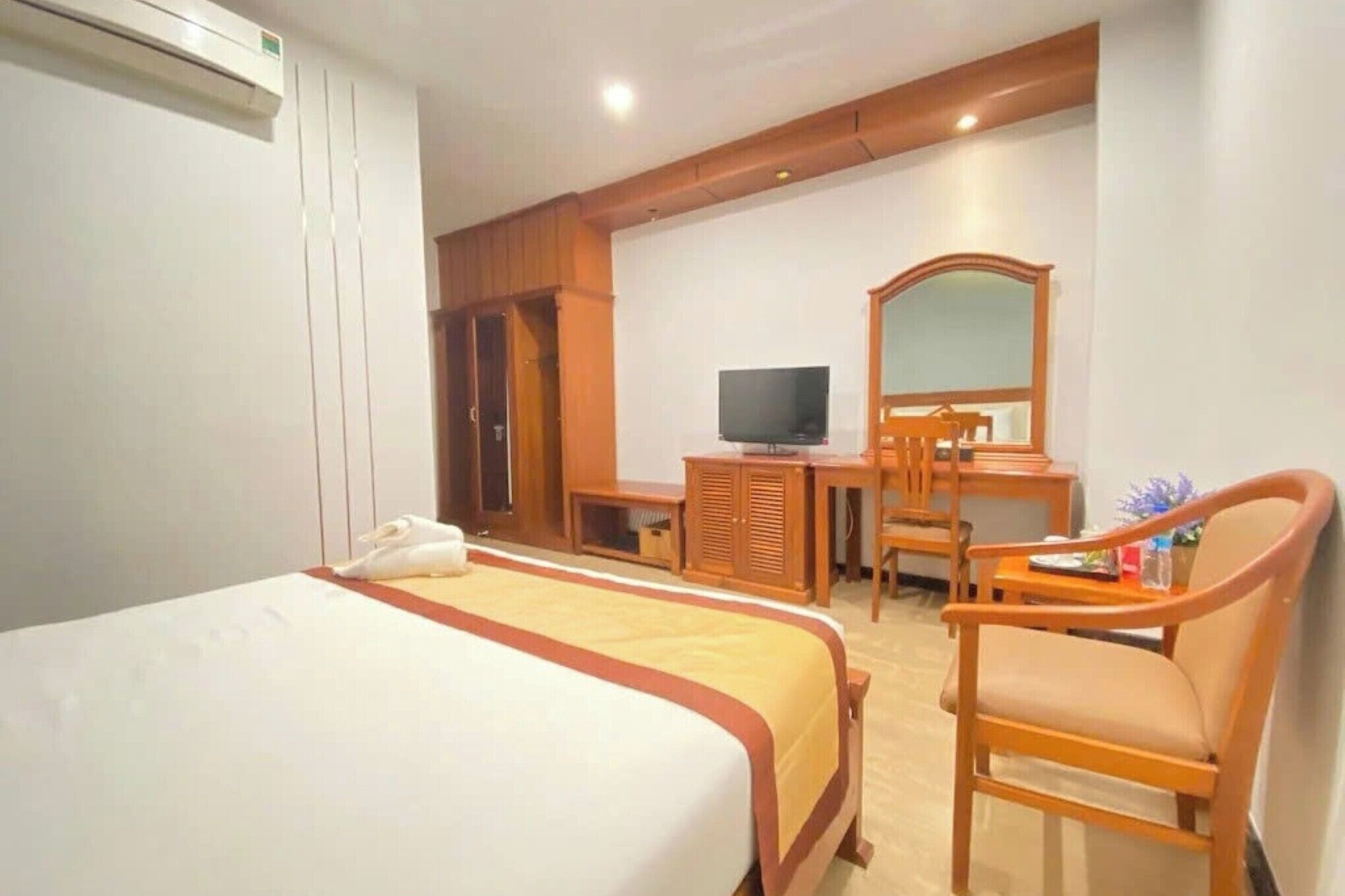 Habitación de hotel con dos camas, televisión, escritorio y una silla.