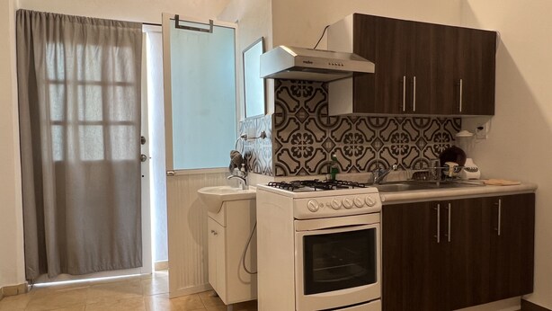 Une cuisine équipée d’une cuisinière, d’un four, d’un évier et d’un cr édence décorée.