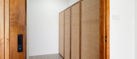 A hallway with a wooden door, a sliding shoji screen, and a light switch on the wall.