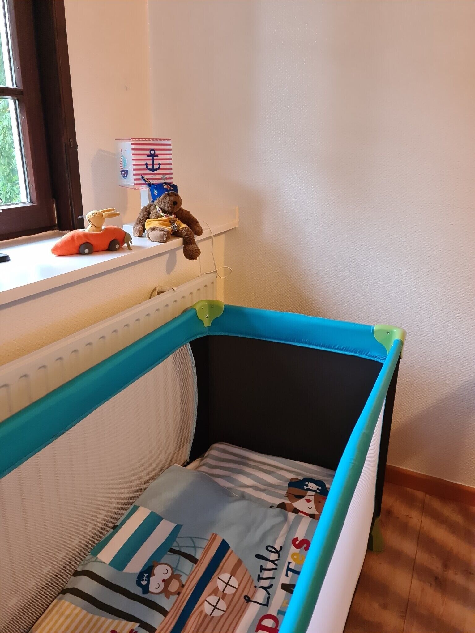 A crib with a blue frame and a mattress with a nautical theme.