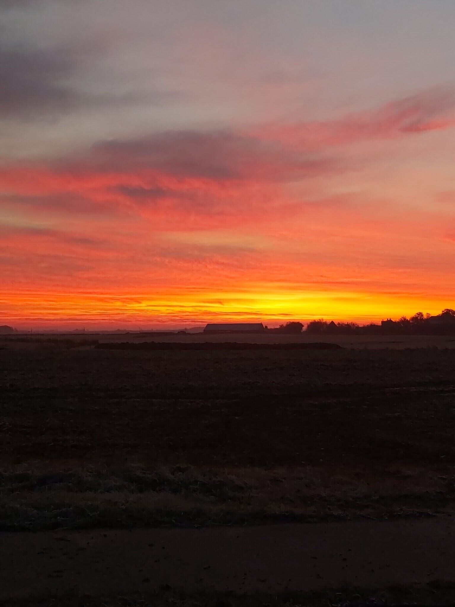 Eine flache Landschaft mit Horizont und blauem Himmel.