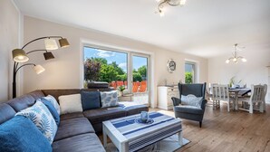 Un salon moderne avec un canapé, une table basse et un coin repas.