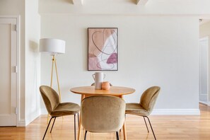 Relax in a serene space with a round table, comfortable chairs, and a beautiful abstract artwork.