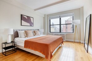 Relax in a stylish room with a large bed, black nightstand, and city view.