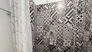 A bathroom with a toilet, a shower with a patterned tile wall, and a curtain. - Apartment 32mt2 Tultitlán Edomex. Near the municipal palace. Beautiful garden  (Tultitlán de Mariano Escobedo)