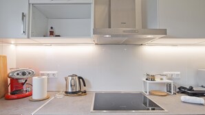 A modern kitchen with a built-in stove, a coffee machine, and a kettle. - Athina in Chalandri With 2 Bedrooms and 1 Bathrooms (Chalandri)