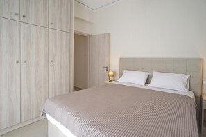 A bedroom with a bed, a nightstand, and a wardrobe. - Piraeus Wave in Piraeus (Piraeus)