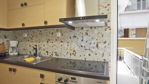 Eine Küche mit modernem Design, ausgestattet mit einem Edelstahlspülbecken, einem eingebauten Herd und Holzschränken.