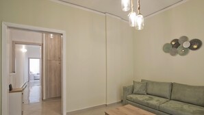 Ein Wohnzimmer mit einem grünen Sofa, einem Holztisch und einem Wandbild.
