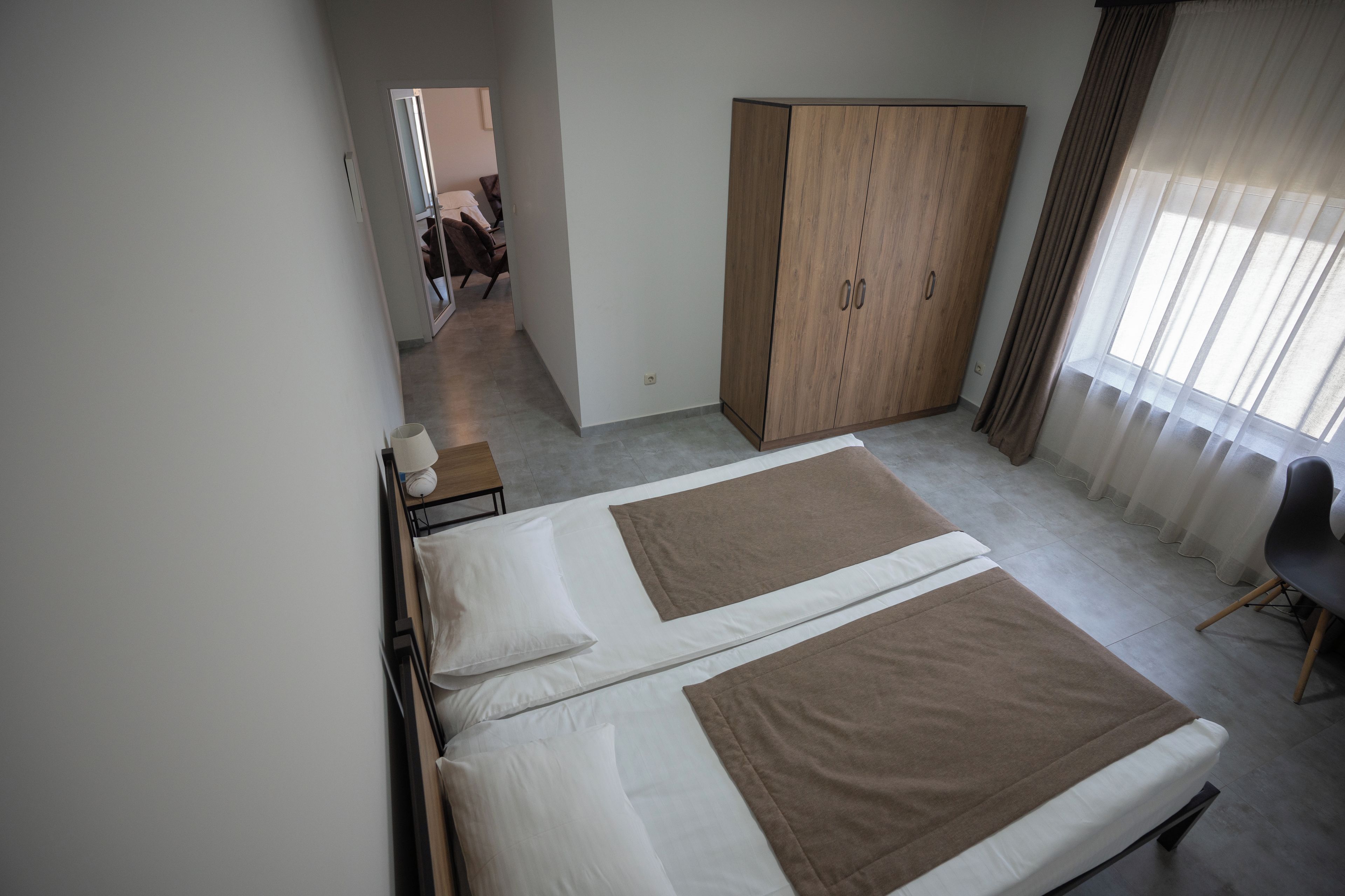 Une chambre d’hôtel comprenant un lit, une armoire, un bureau et une chaise.