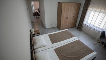 Une chambre d’hôtel comprenant un lit, une armoire, un bureau et une chaise.