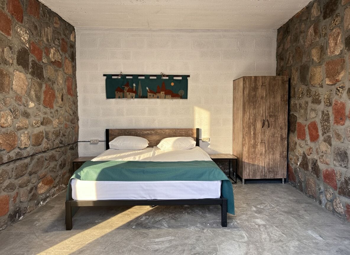 Una camera da letto con un letto, un comodino, un armadio e un quadro appeso al muro.