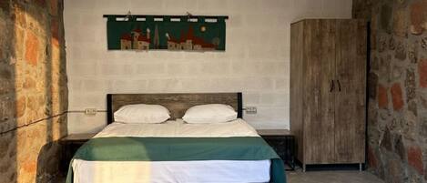 A bedroom with a bed, a wall-mounted artwork, and a wardrobe.
