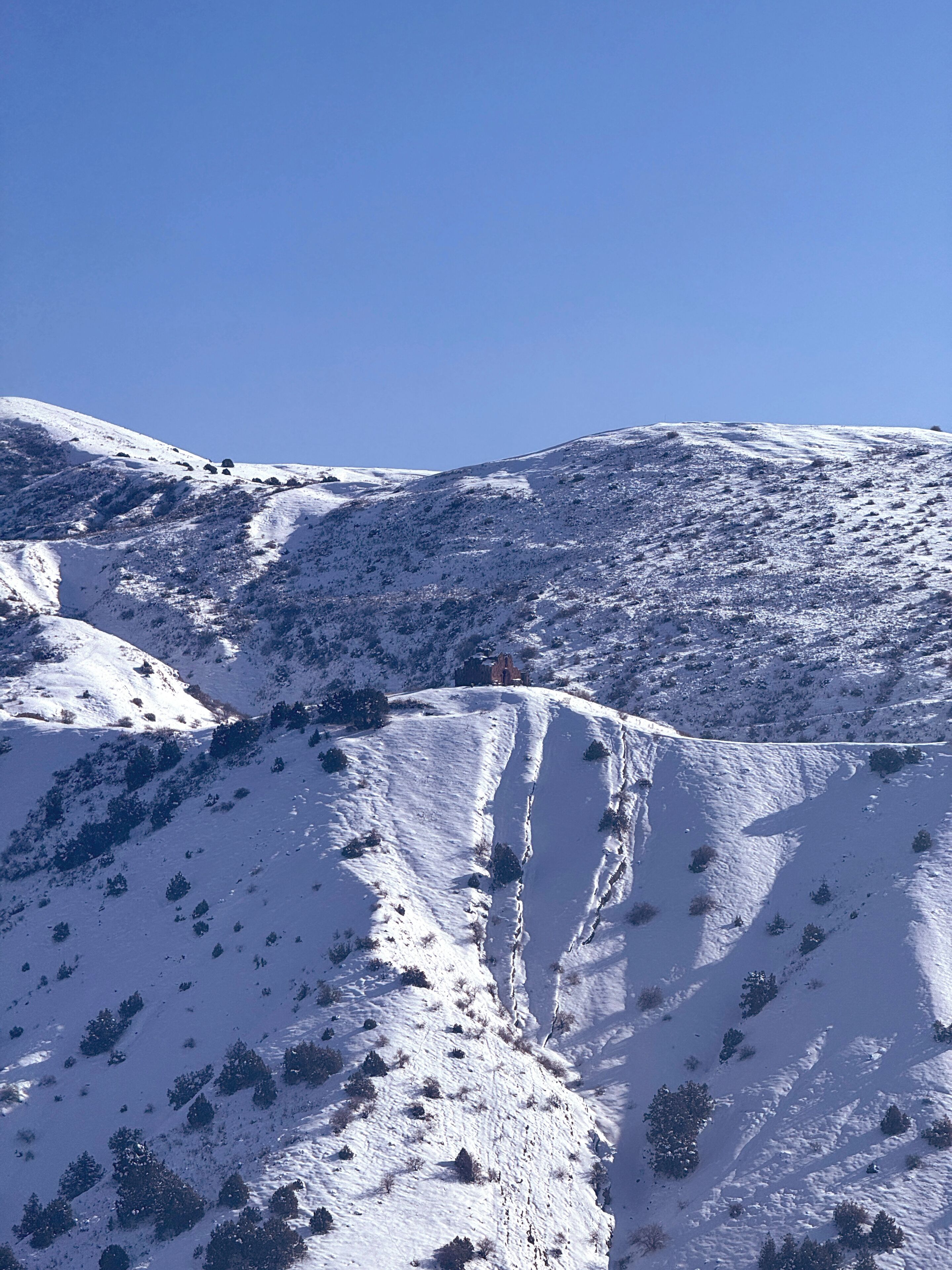 A snow-covered mountain landscape with a clear sky.