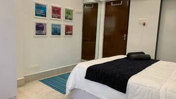 Un dormitorio con una cama, un tapete azul y seis citas enmarcadas en la pared.