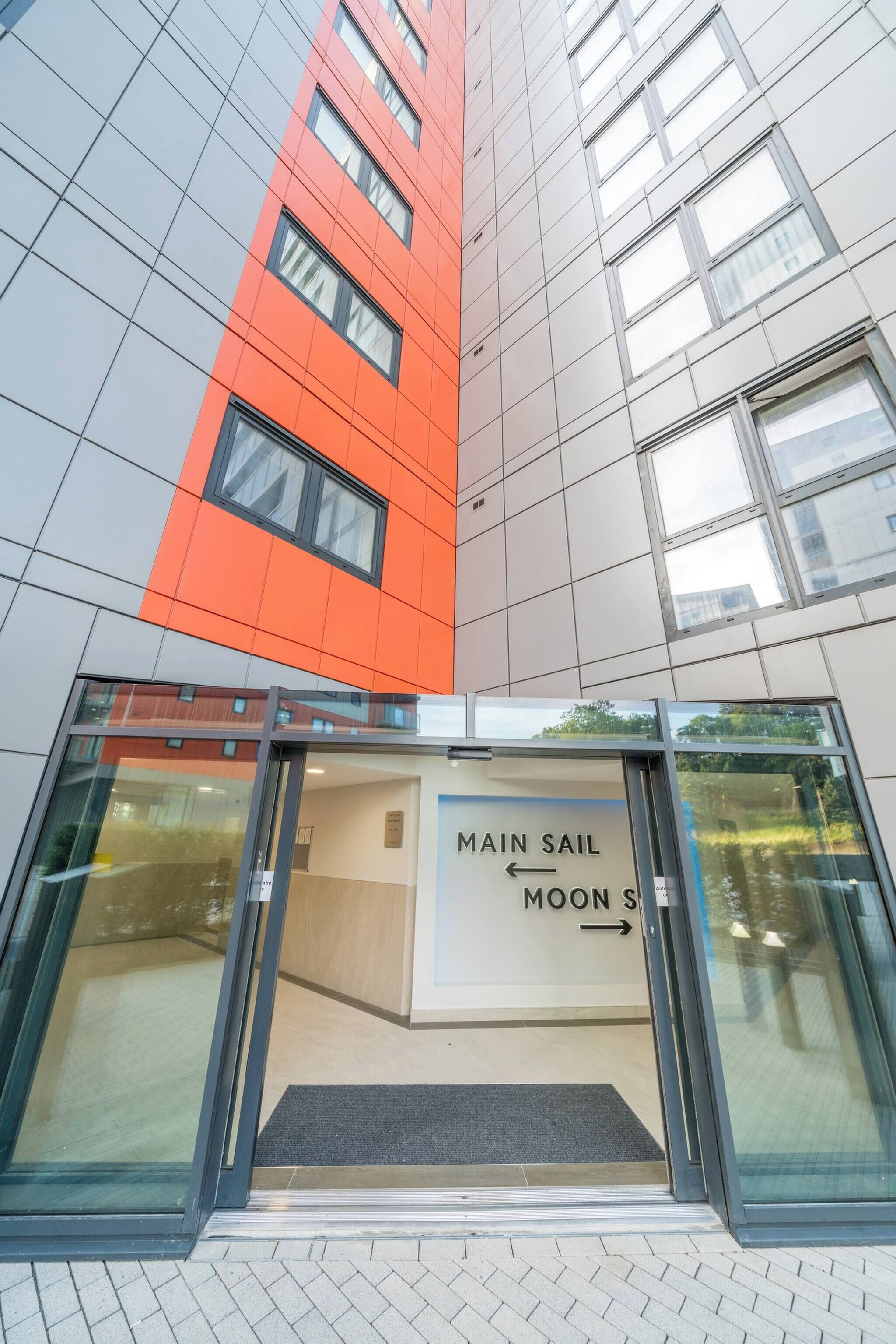 A building entrance with a sign indicating directions to 'Main Sail' and 'Moon's.'