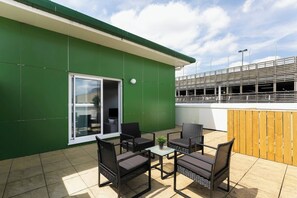 A patio with outdoor furniture, a sliding glass door, and a view of a construction site. - Skyvillion - Huge 4bed Apartment Wbalcony - Parking (Enfield)