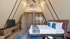 A modern, well-lit room with a bed, bedside table, and a television.