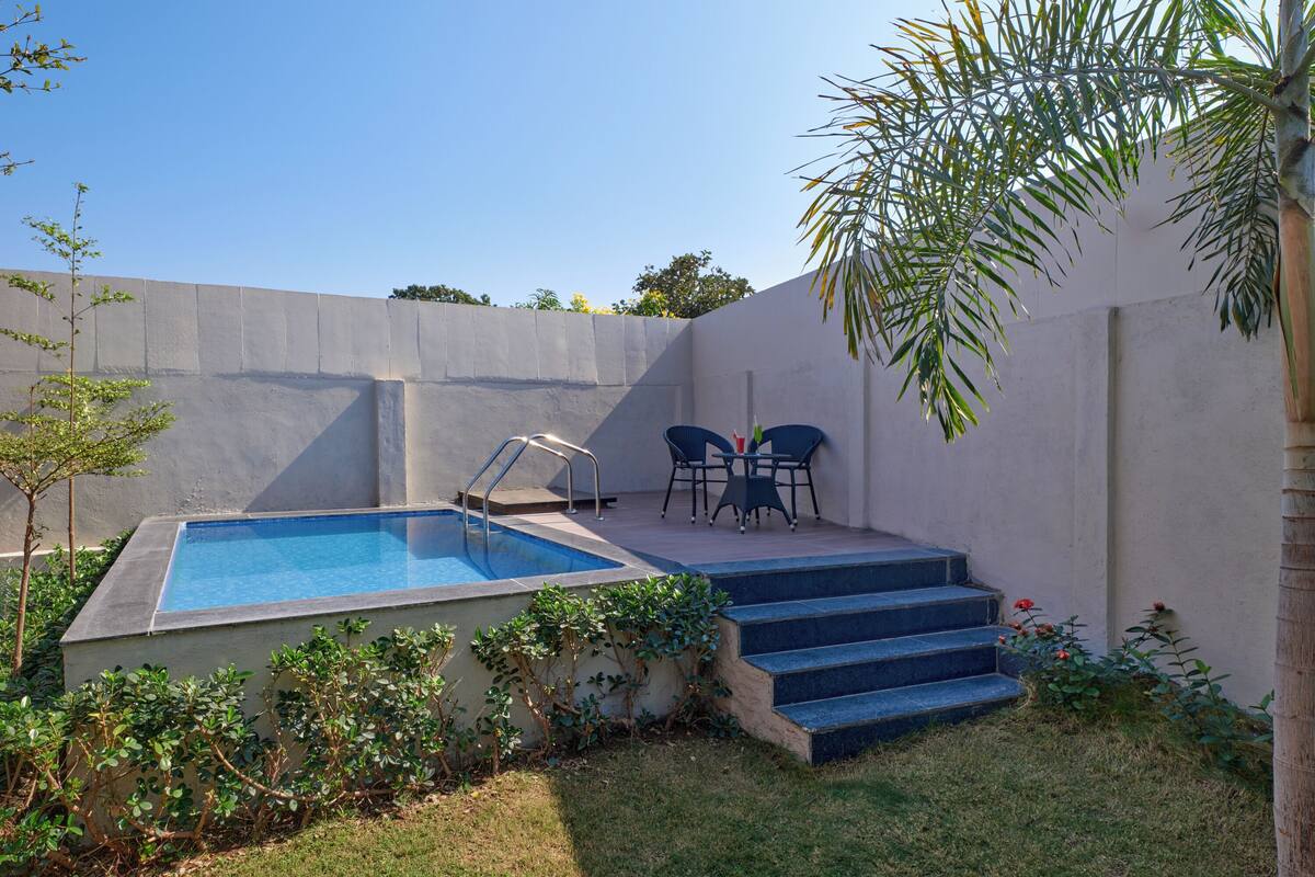 A rectangular swimming pool with steps leading up to a patio area.
