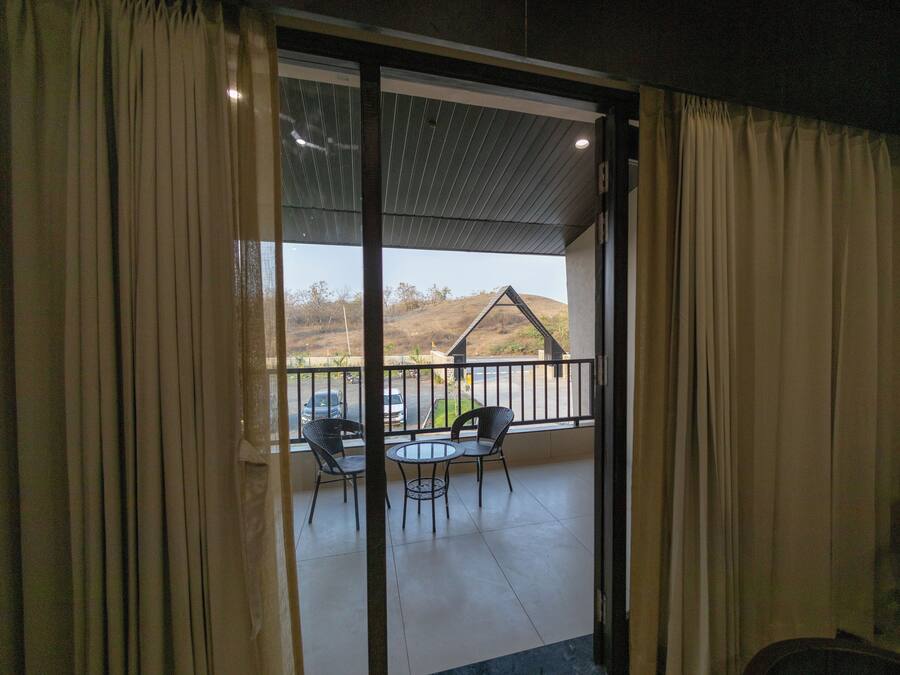 A room with a sliding glass door leading to an outdoor balcony with a table and chairs.