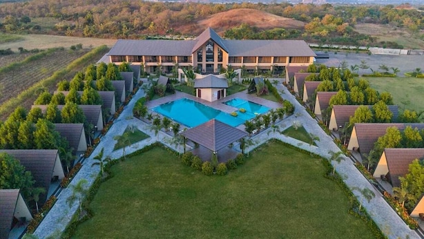 A resort with multiple bungalow-style accommodations, a central pool, and a landscaped garden.