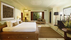 Un dormitorio amplio con una cama grande, un sofá y un televisor.