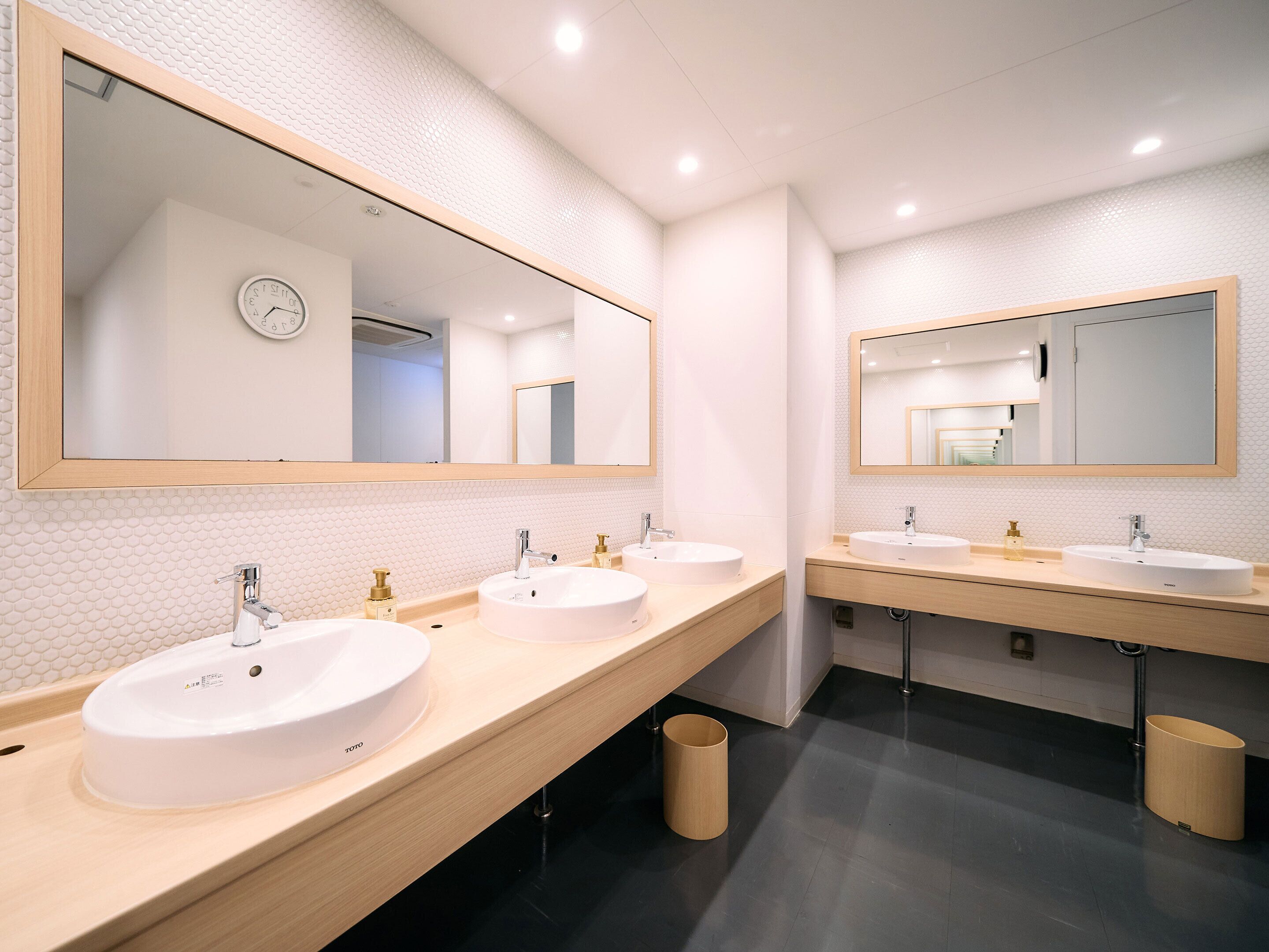 A modern bathroom with two sinks, large mirrors, and a tiled backsplash.