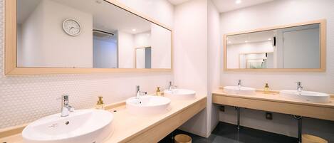 A modern bathroom with two sinks, large mirrors, and a tiled backsplash.
