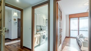 Un apartamento moderno con zona de lavandería, kitchenette y un dormitorio con vistas.