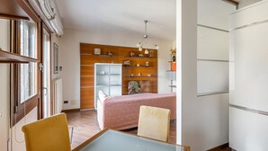 Un espace de vie compact comprenant un coin repas, une kitchenette et un lit.