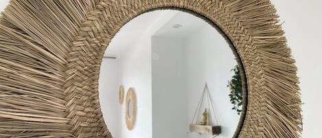 A round mirror with a woven frame.