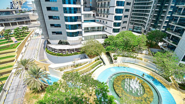 A modern high-rise building with a curved swimming pool and surrounding greenery. - Premium 3BR Partial Sea View OCEANA (Dubai)