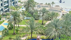 A resort with a large pool area surrounded by palm trees, a dock, and a view of the sea. - Premium 3BR Partial Sea View OCEANA (Dubai)