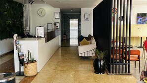 A hotel reception area with a reception desk, a lounge area with seating, and directional signs for the reception, lobby bar, and restaurant. - Cot Hotel (Addis Ababa)