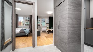 Ein modernes Apartment mit einem Bett, einem kleinen Tisch und Blick auf umliegende Gebäude.